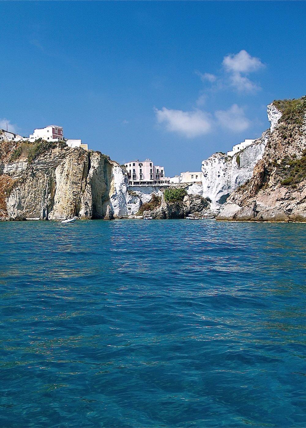 Vista sul mare limpido e sulla costa di Ponza con case arroccate, scorcio tipico dell’isola pontina