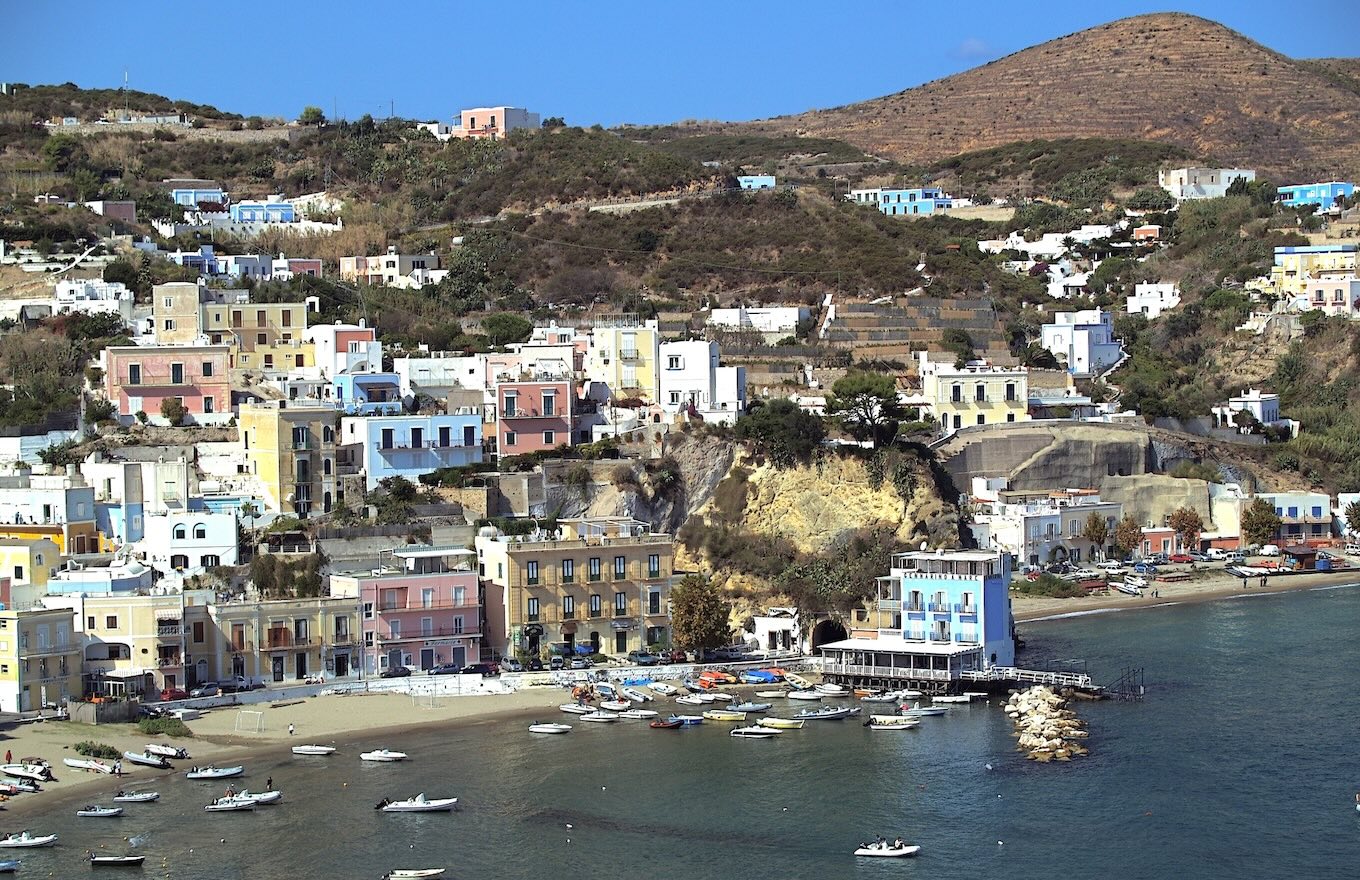 Spiaggia di Ponza con barche ormeggiate e case colorate, raggiungibile in aliscafo da Anzio con Vetor